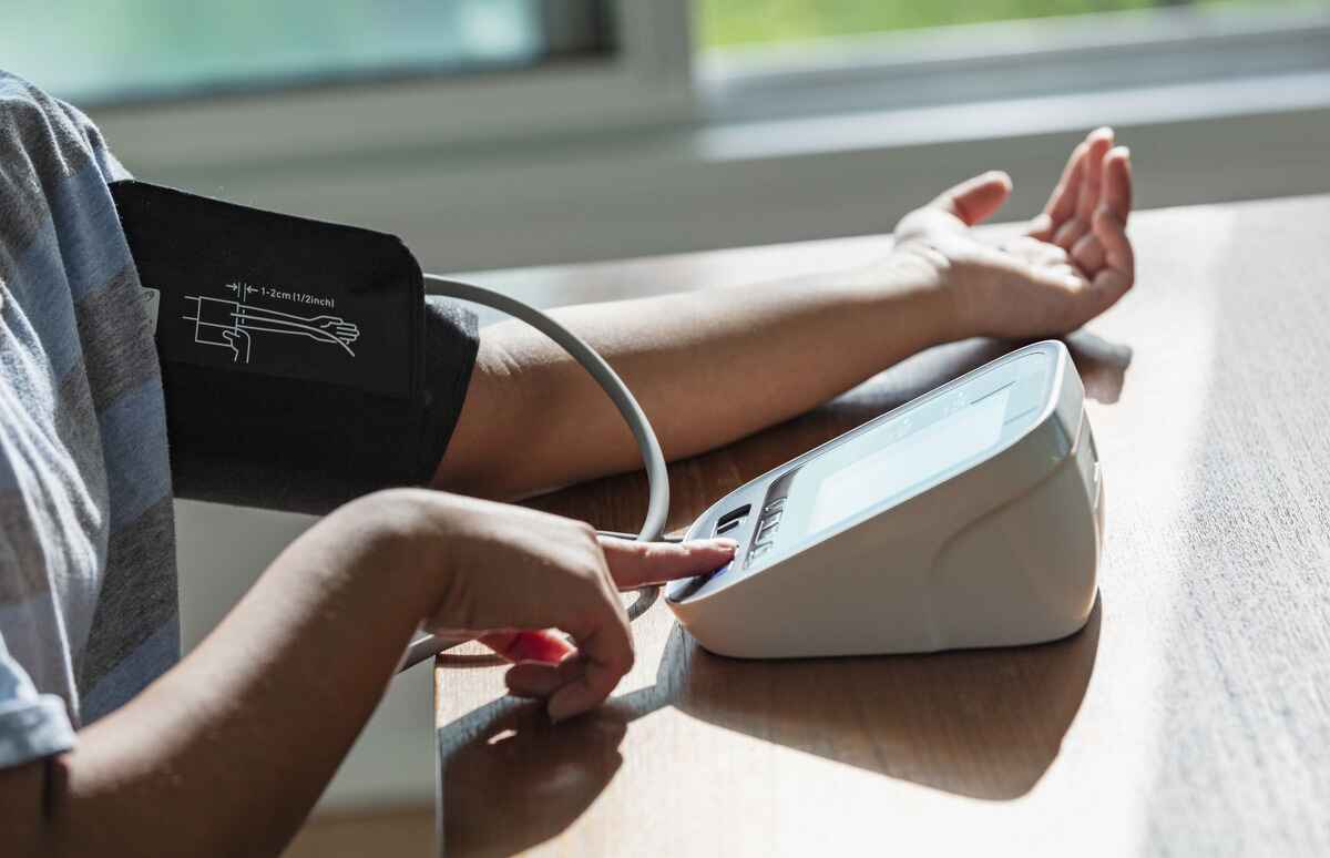 Person measures their blood pressure with a blood pressure cuff